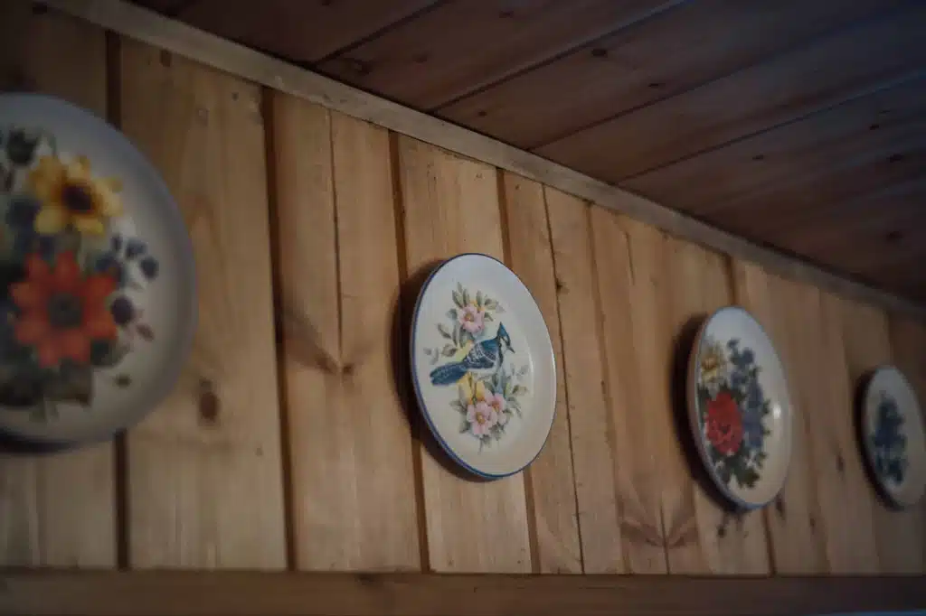 Attic wood-panelled wall with two decorative painted plates, Valaes Guesthouse, Foiniki