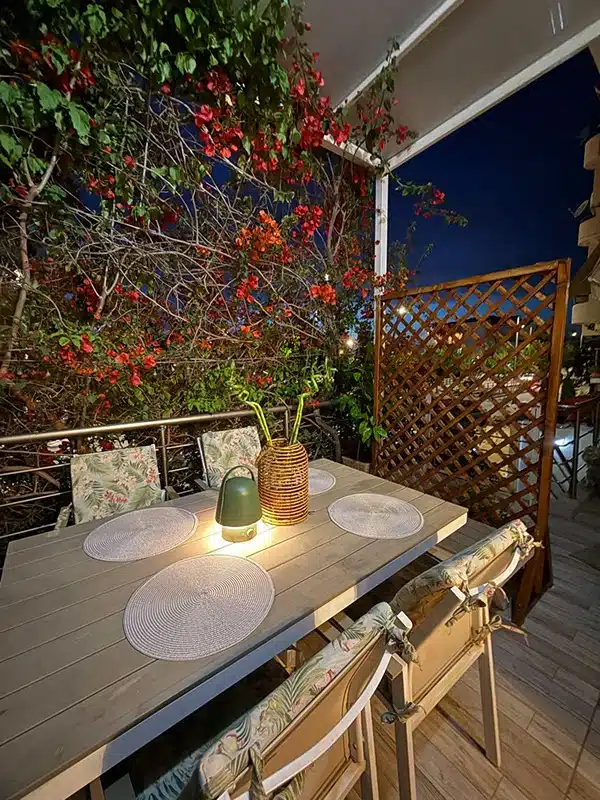 Balcony with dining table under bougainvillea at Ledeza Apartment in Igoumenitsa"