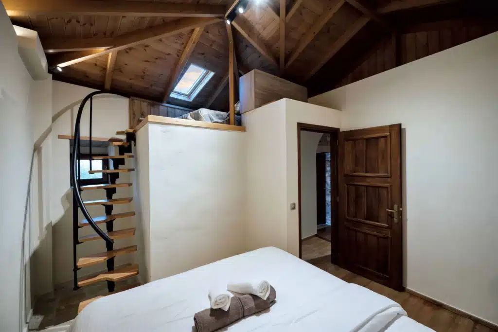 Bright bedroom with a double bed, beamed ceiling, staircase and wooden door, Valaes Guesthouse, Foiniki