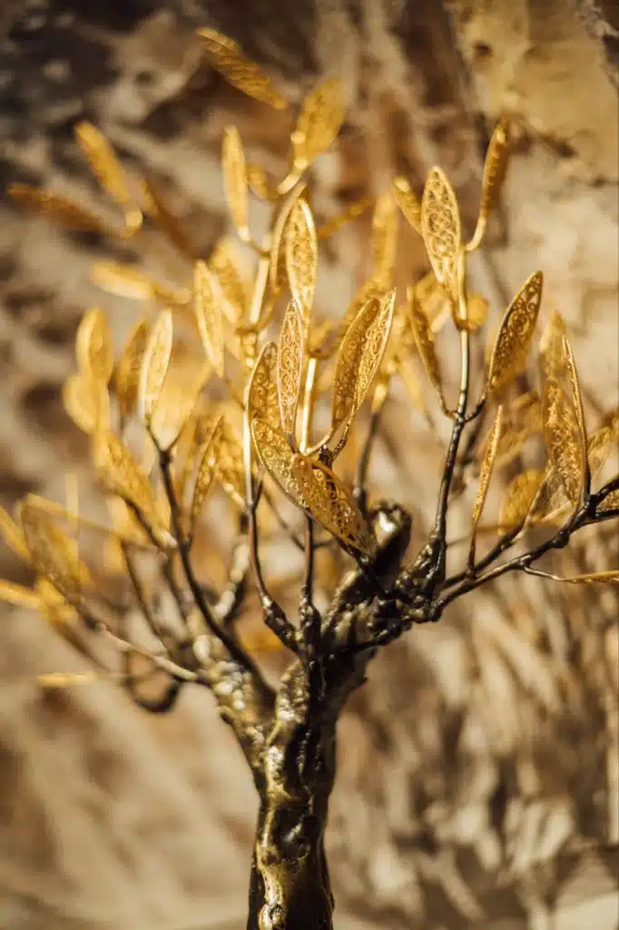 Close-up of a golden olive branch, the Valaes signature motif, Foiniki