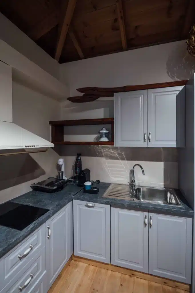 Compact kitchenette with cabinets and sink in a suite, Valaes Guesthouse, Foiniki