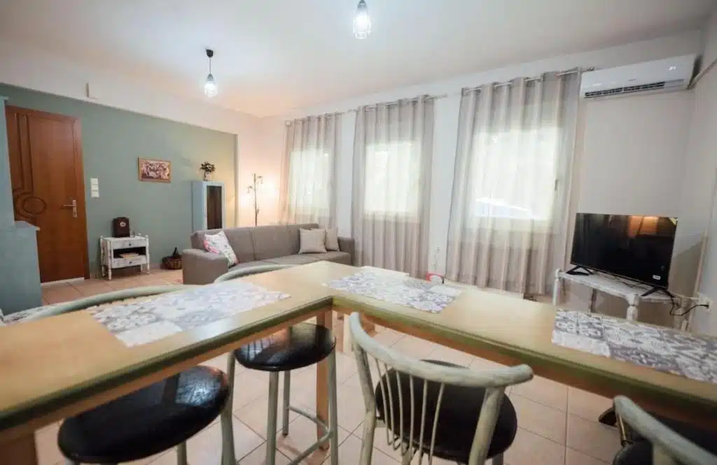 Living room with a breakfast bar, stools, a TV and an air conditioner
