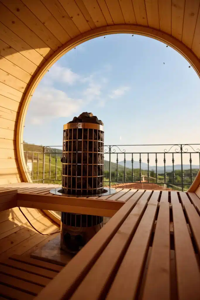 Interior of the barrel sauna with wooden benches and a mountain view, Valaes Guesthouse, Foiniki