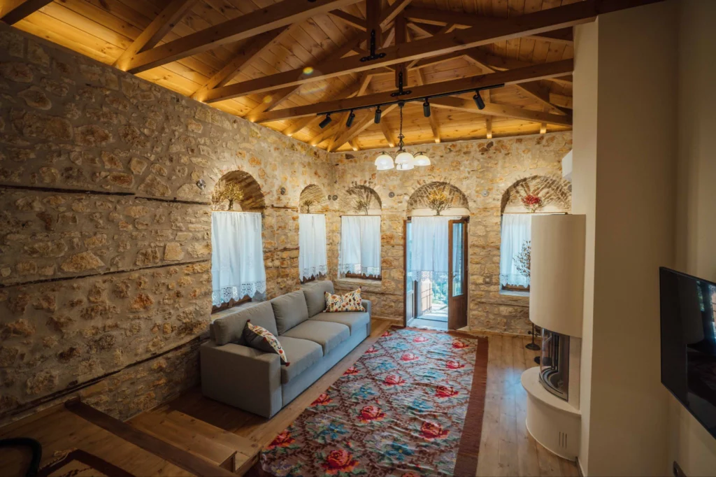 Living room with sofas, arched windows and a colourful traditional rug, Valaes Guesthouse, Foiniki