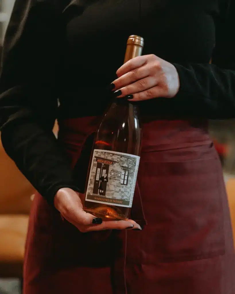 Eine Flasche Wein von Markatselis in der Hand.