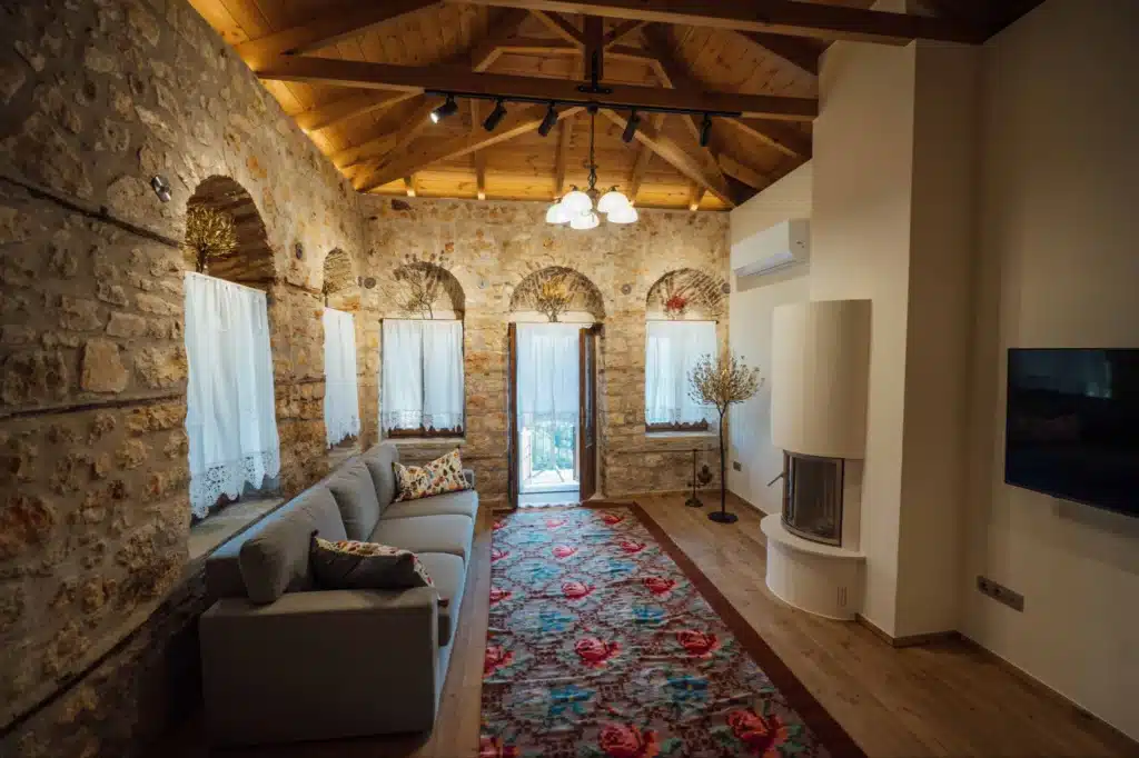 Open-plan living room with arched windows and a fireplace, Valaes Guesthouse, Foiniki