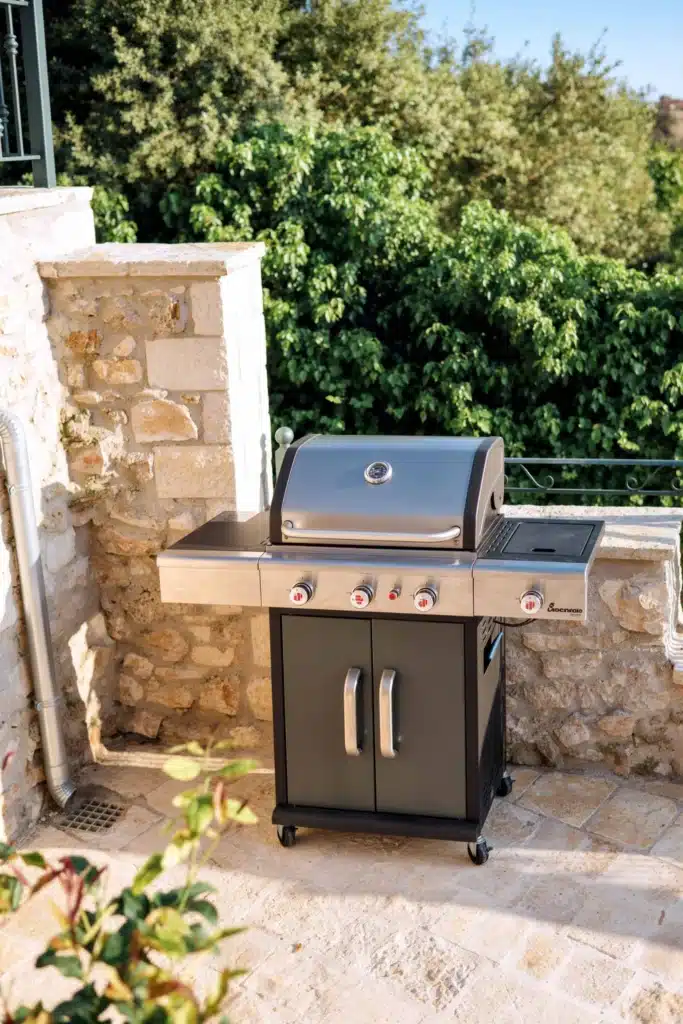 Outdoor barbecue area by a stone wall, Valaes Guesthouse, Foiniki