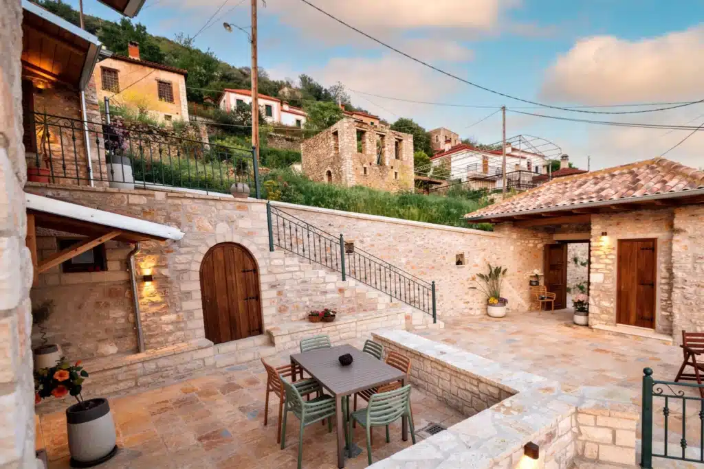 Outdoor courtyard dining table with string lights and a village view, Valaes Guesthouse, Foiniki