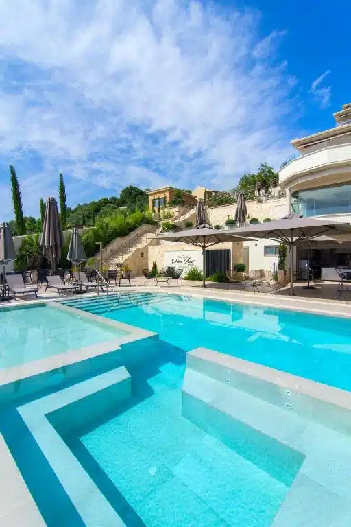 Pool terrace with sunbeds at Prima Vista above Agia Paraskevi beach