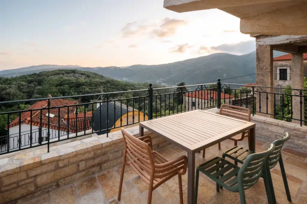Private balcony with a table and chairs and a sunset view over the mountains, Valaes Guesthouse, Foiniki
