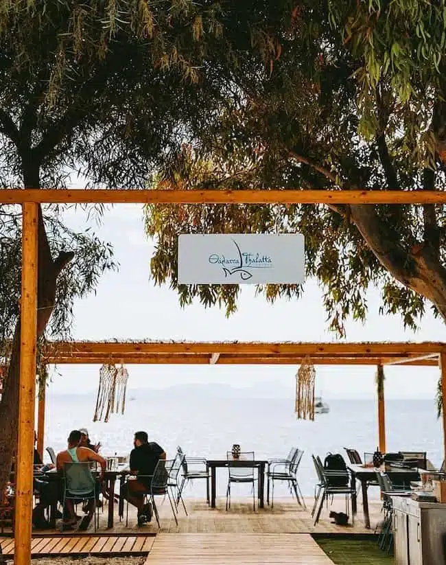 Seafront dining area at Thalatta Taverna in Plataria, Greece, overlooking the Ionian Sea at sunset