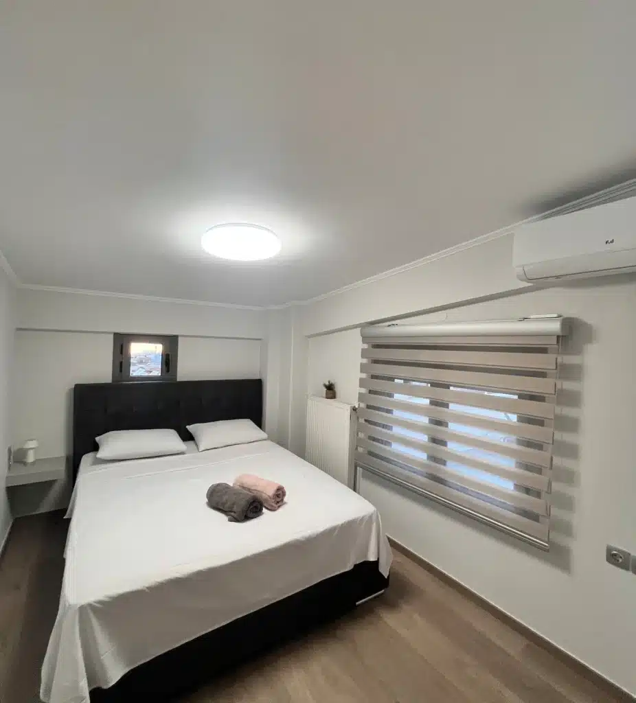 Bedroom with a double bed, window blinds and air conditioning