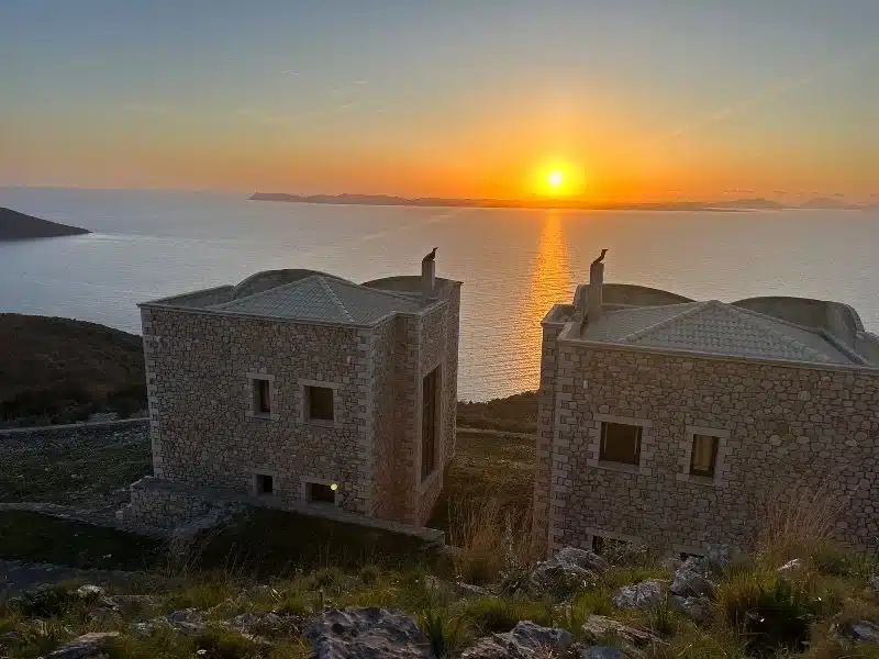 Πέτρινα κτίσματα με θέα στη θάλασσα την ώρα του ηλιοβασιλέματος
