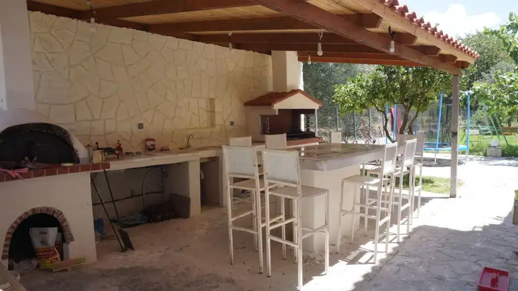 Covered outdoor kitchen area with bar seating at Casa di campagna